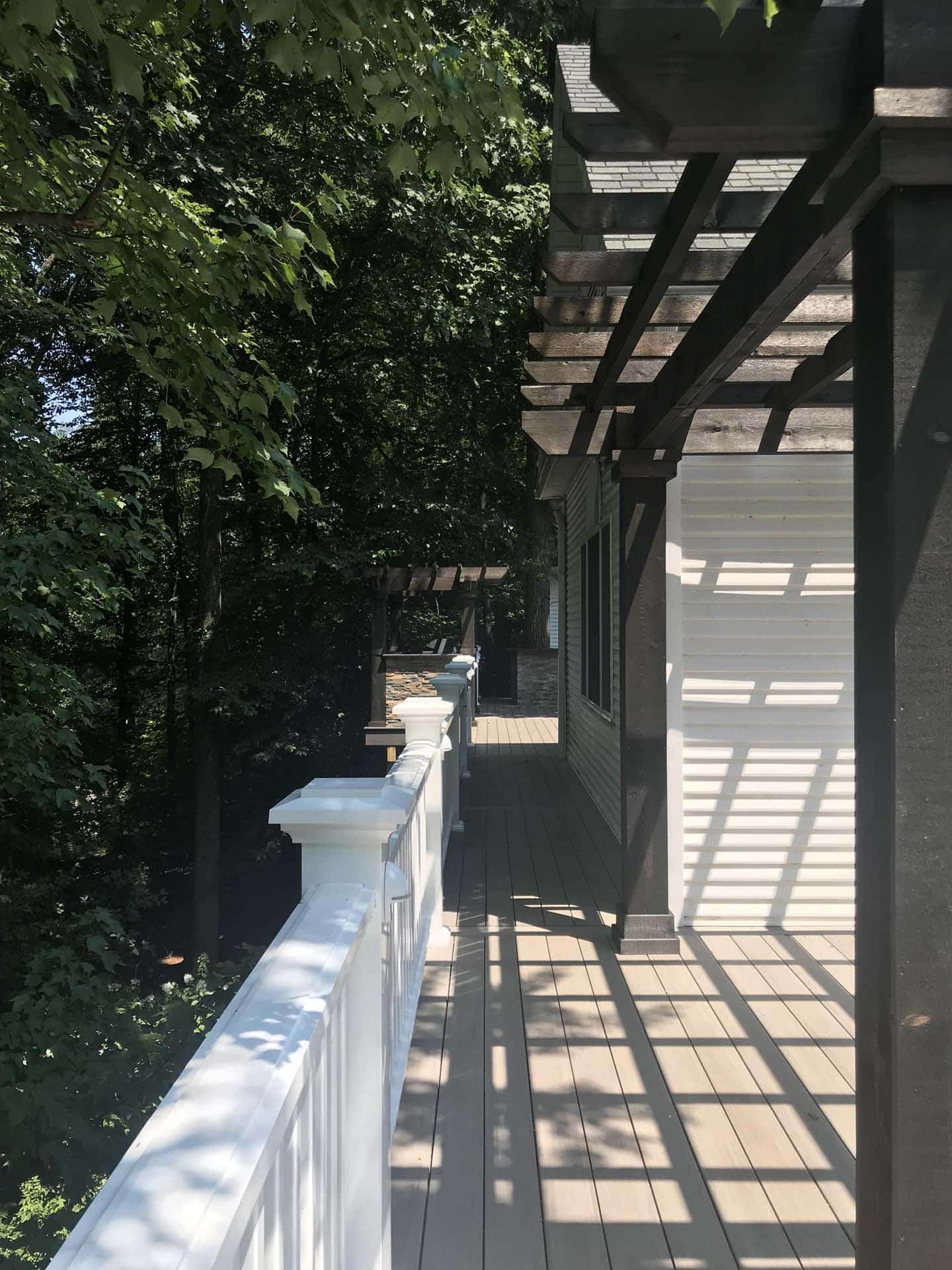 porch area with white railing, black pergola