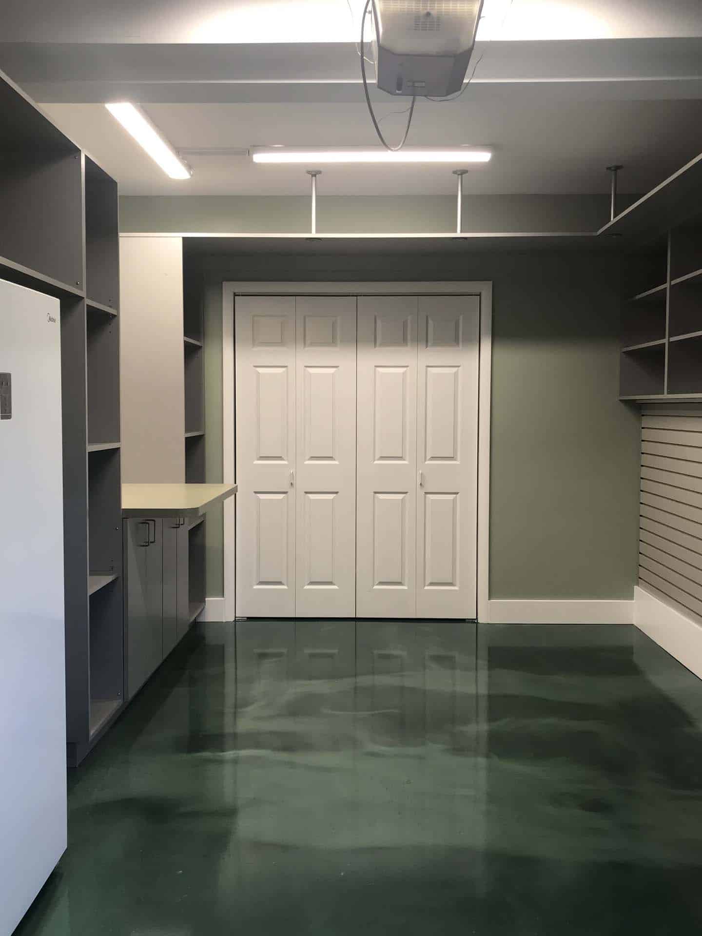 garage with white closet doors, green walls and flooring