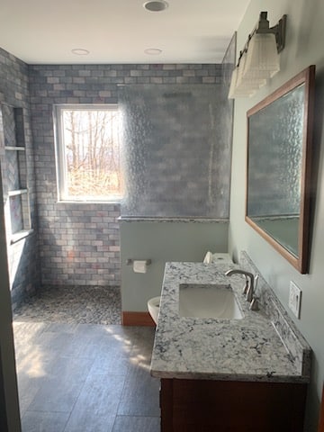 bathroom with stone shower and tile sink